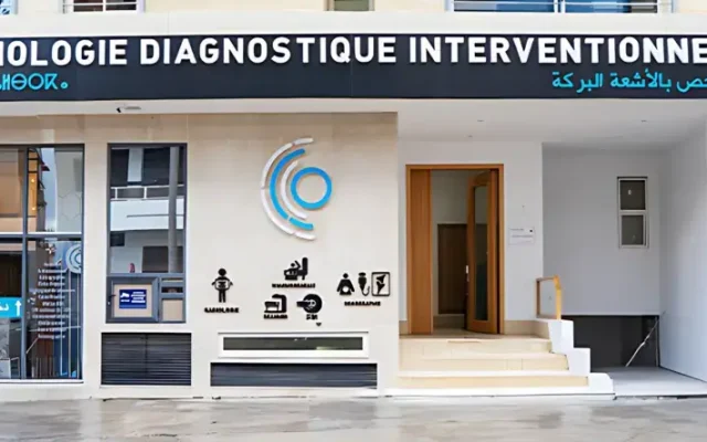 Exterior of a diagnostic radiology clinic with a large bilingual sign across the top, glass entry windows, and a blue circular logo on the wall.
