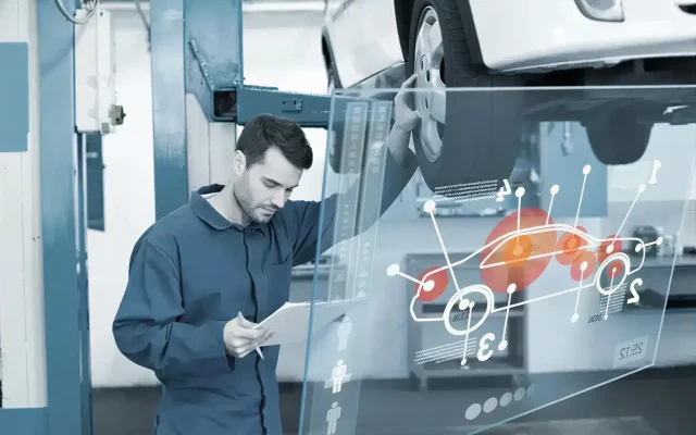 Maintenance technician analyzes data displayed on a holographic screen beside a raised car in a workshop.